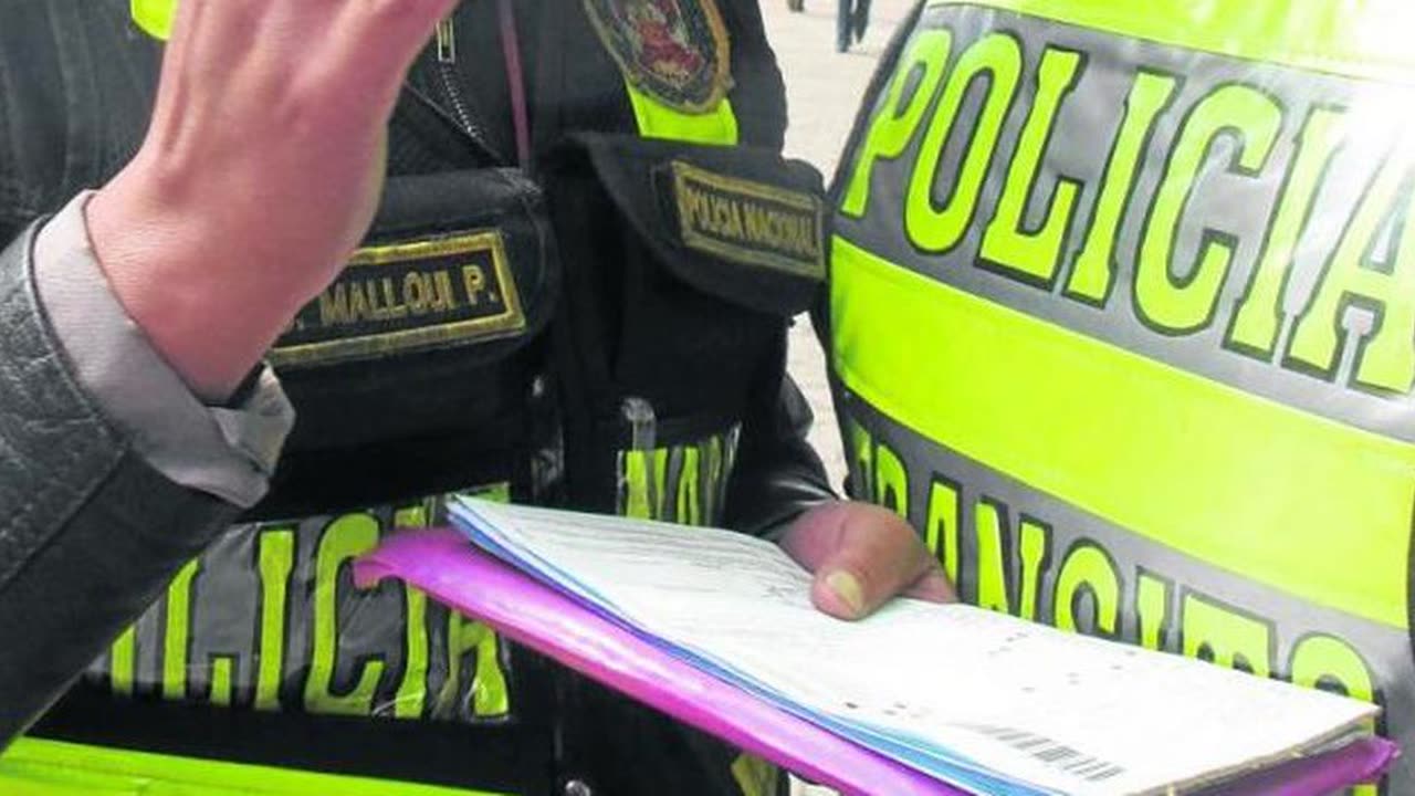 Policía de tránsito peruano escribiendo en un talonario de papeletas