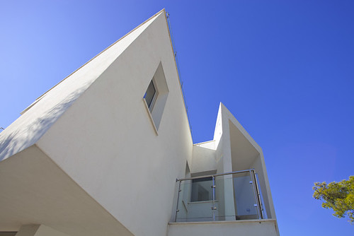Fachada de un edificio moderno de paredes blancas contra un cielo despejado