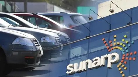 Autos estacionados frente al letrero azul de una oficina de la Sunarp