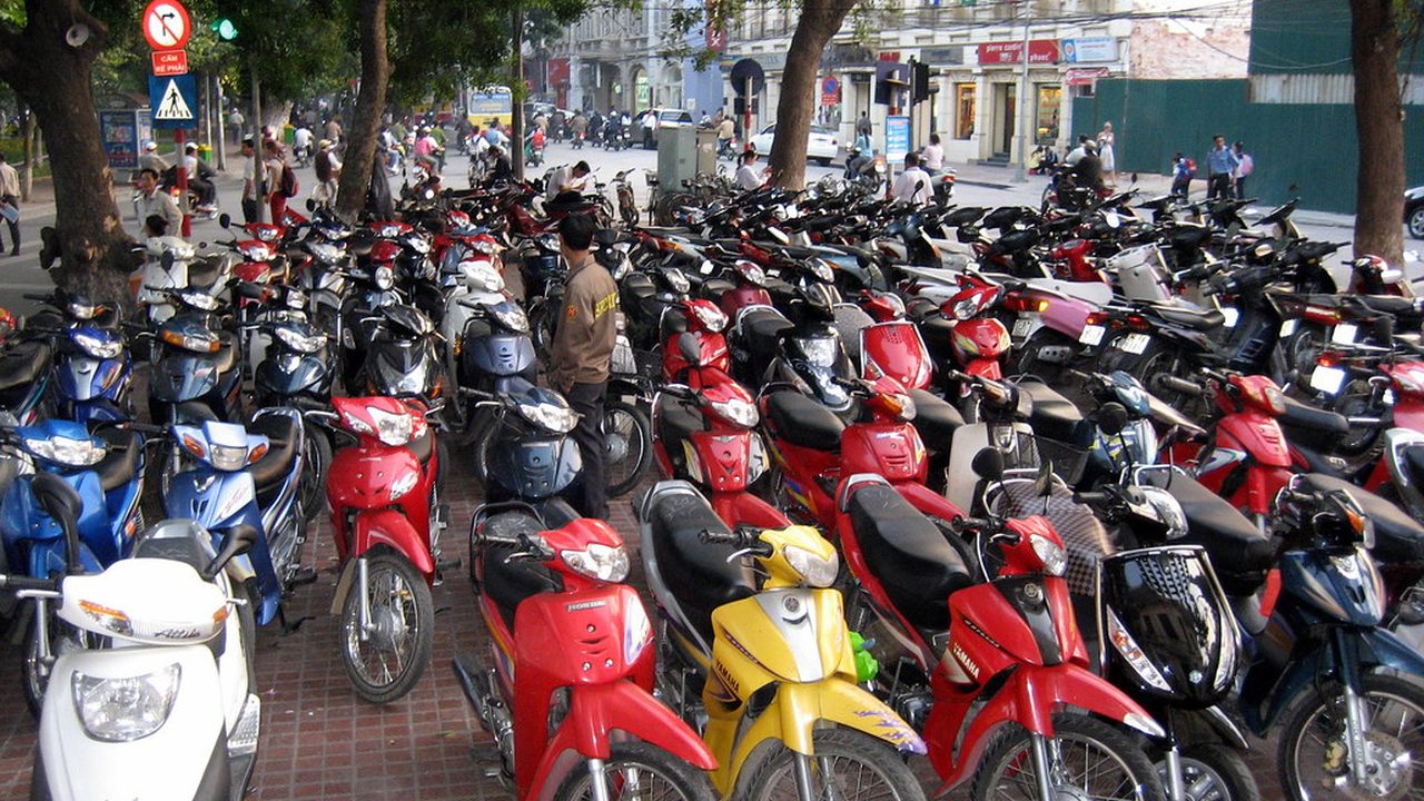Decenas de motos lineales estacionadas en fila sobre una vereda