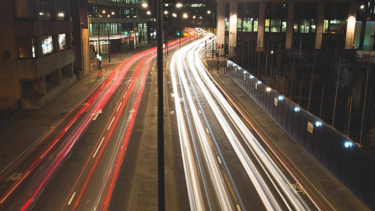 Estelas de luz rojas y blancas dejadas por los autos en una avenida de noche