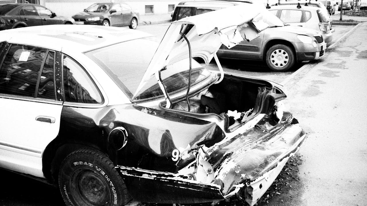 Auto con el frente destrozado tras un choque, fotografiado en blanco y negro